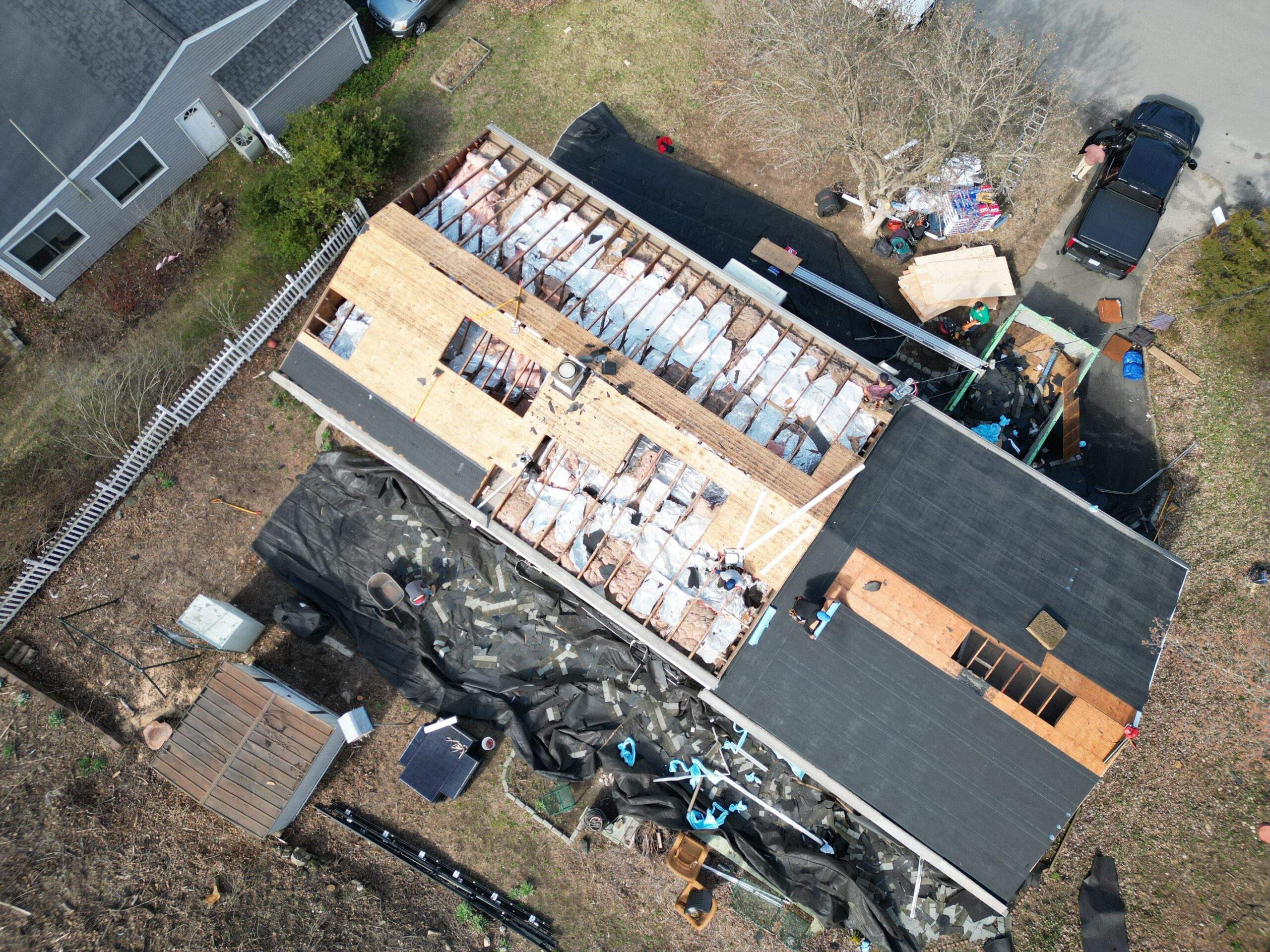 Xpert Roofing Pro crew performing a full roof replacement in Bethel CT, removing old shingles and installing new plywood decking.